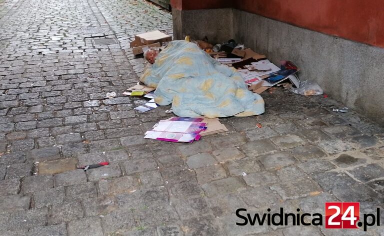 Bezdomny pod kołdrą naprzeciwko Sądu Okręgowego w Świdnicy. Nie można siłą umieścić go w schronisku, noclegowni nie ma