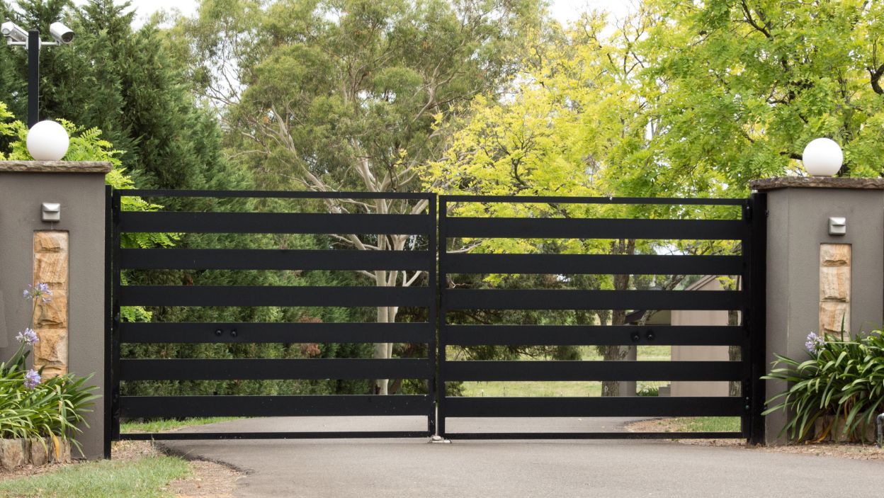 Ogrodzenie na lata – dlaczego warto inwestować w solidne zawiasy i szyny do bram?