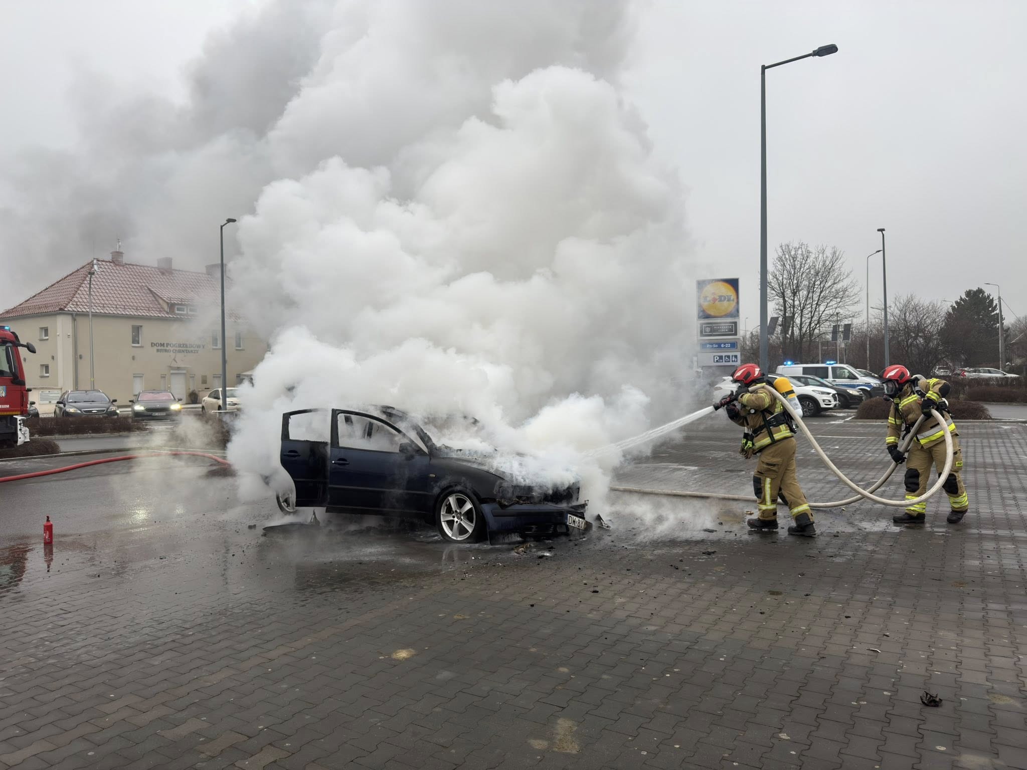 Pożar samochodu na parkingu przed dyskontem [FOTO]